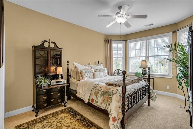 bedroom with light colored carpet, visible vents, ceiling fan, and baseboards