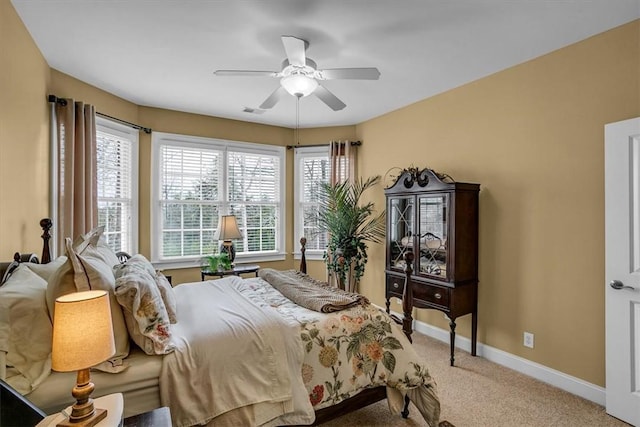 bedroom with a ceiling fan, visible vents, baseboards, and carpet flooring