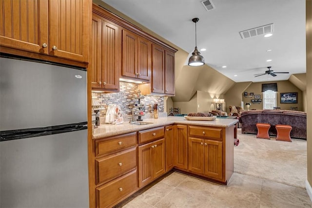 kitchen with light carpet, freestanding refrigerator, visible vents, and a peninsula