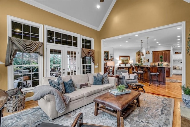 living area featuring high vaulted ceiling, light wood-type flooring, french doors, and crown molding