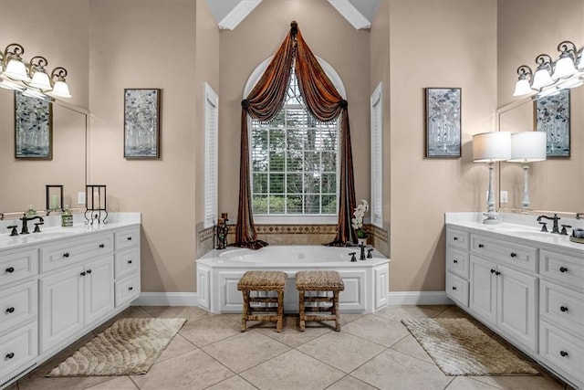 bathroom with a sink, baseboards, two vanities, and tile patterned floors