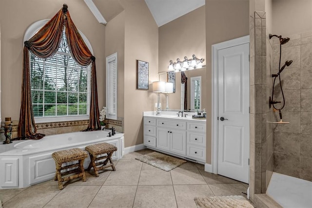 bathroom with a bath, a tile shower, vanity, and tile patterned floors