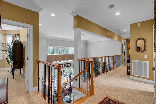 hallway with carpet, an upstairs landing, visible vents, and baseboards