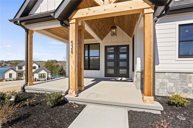 entrance to property featuring a water view, covered porch, and board and batten siding