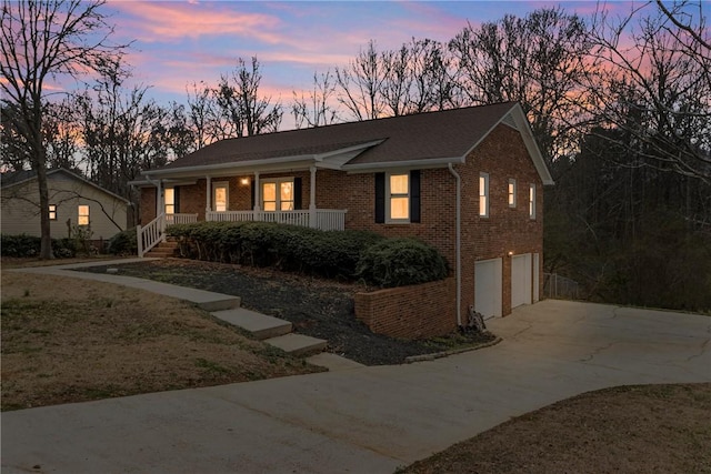 ranch-style house with a garage, covered porch, concrete driveway, and brick siding