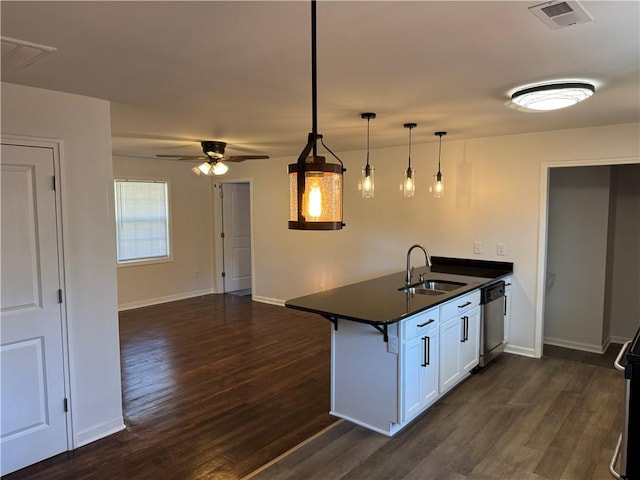 kitchen featuring a peninsula, a sink, visible vents, stainless steel dishwasher, and dark countertops