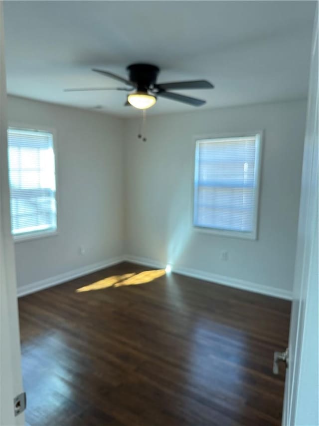 empty room featuring ceiling fan, wood finished floors, and baseboards