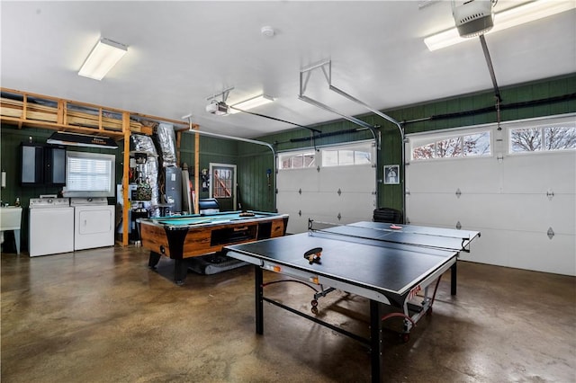 garage with a garage door opener, gas water heater, a sink, and washer and clothes dryer