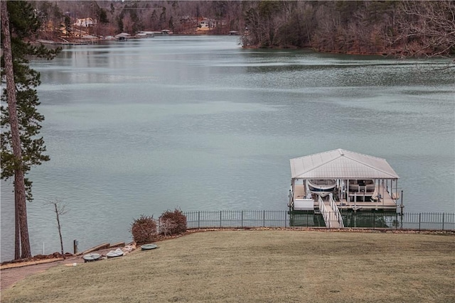 view of water feature featuring boat lift, a boat dock, and fence