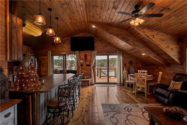 living area featuring light wood-style floors, wooden ceiling, ceiling fan, vaulted ceiling, and wood walls