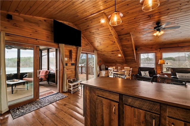 kitchen featuring lofted ceiling, hardwood / wood-style floors, plenty of natural light, and wooden walls