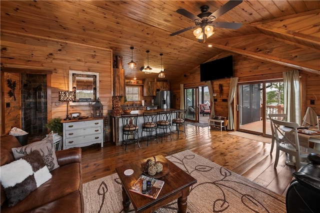 living room featuring a ceiling fan, hardwood / wood-style flooring, wood ceiling, wood walls, and high vaulted ceiling