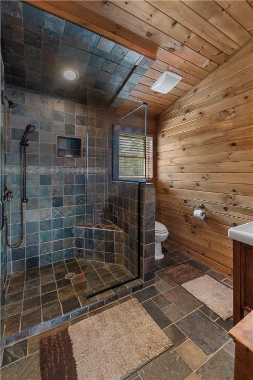 bathroom featuring wood ceiling, a shower stall, vanity, and toilet