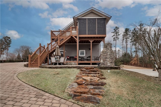 rear view of property with a wooden deck, stairs, and a yard