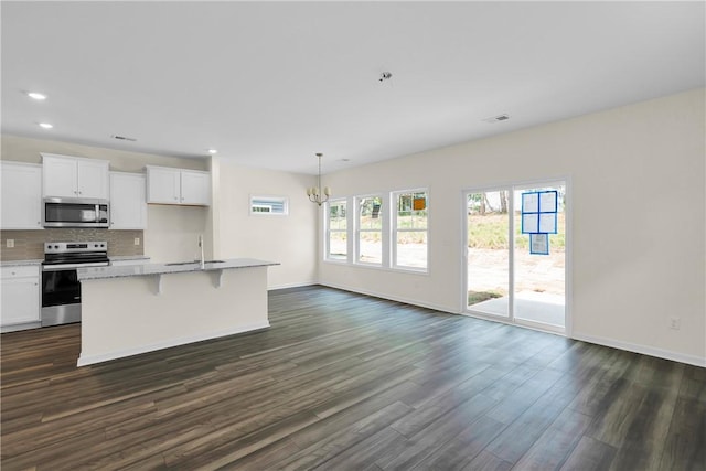 kitchen featuring visible vents, baseboards, dark wood-style floors, a sink, and appliances with stainless steel finishes