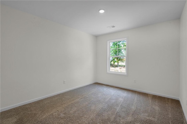 carpeted spare room with baseboards and visible vents