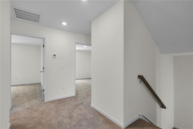 hall with carpet, an upstairs landing, recessed lighting, and visible vents