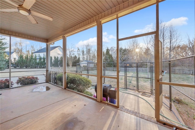 unfurnished sunroom featuring a healthy amount of sunlight and ceiling fan