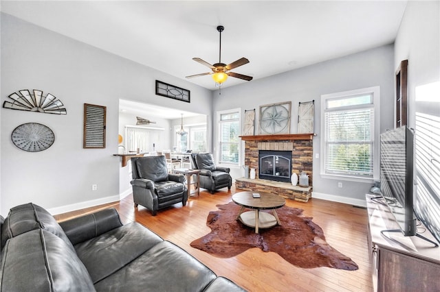 living room with a healthy amount of sunlight, a fireplace, baseboards, and hardwood / wood-style floors