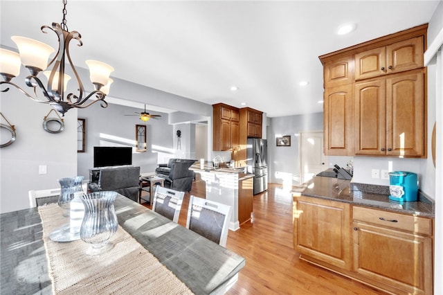 dining room with light wood finished floors, recessed lighting, and ceiling fan with notable chandelier