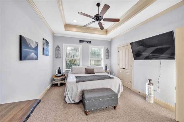 bedroom with crown molding, a closet, a raised ceiling, light colored carpet, and baseboards