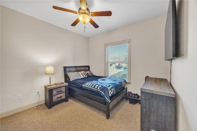 bedroom featuring light carpet, a ceiling fan, and baseboards