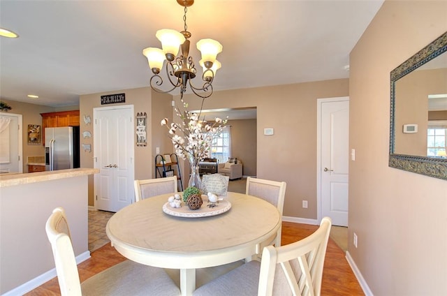 dining space featuring a chandelier, plenty of natural light, and baseboards