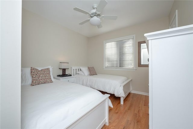 bedroom featuring light wood-style flooring, baseboards, and a ceiling fan