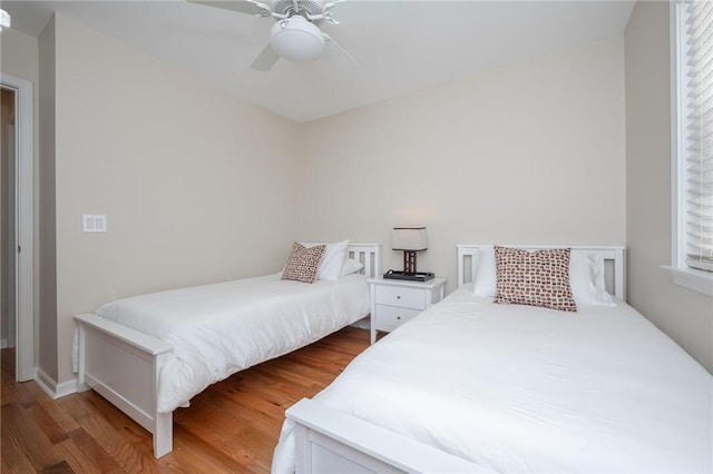 bedroom with ceiling fan, baseboards, and wood finished floors