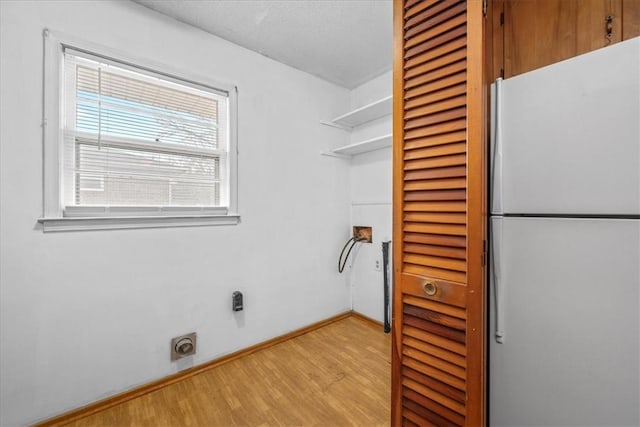 washroom featuring laundry area, light wood finished floors, electric dryer hookup, and baseboards