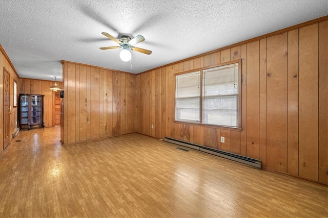 unfurnished room with light wood-style floors, ceiling fan, a baseboard heating unit, and a textured ceiling