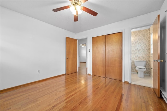 unfurnished bedroom featuring ceiling fan, connected bathroom, baseboards, a closet, and light wood finished floors