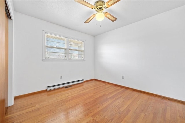 unfurnished room featuring a ceiling fan, baseboards, light wood finished floors, and baseboard heating