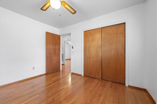 unfurnished bedroom featuring a ceiling fan, a closet, baseboards, and light wood finished floors