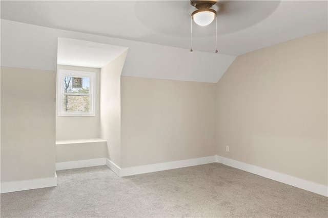 additional living space with light carpet, ceiling fan, baseboards, and vaulted ceiling