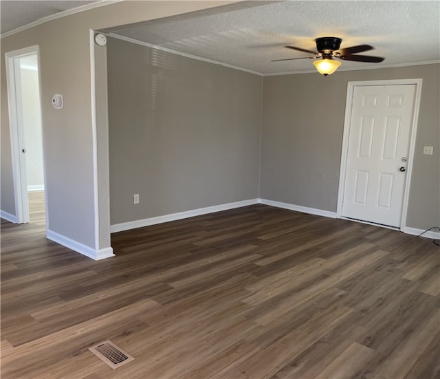 spare room with ornamental molding, visible vents, and dark wood finished floors