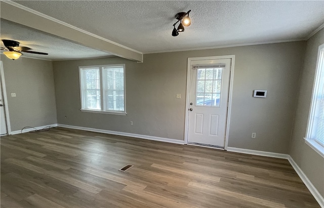 foyer entrance featuring ornamental molding, wood finished floors, visible vents, and baseboards