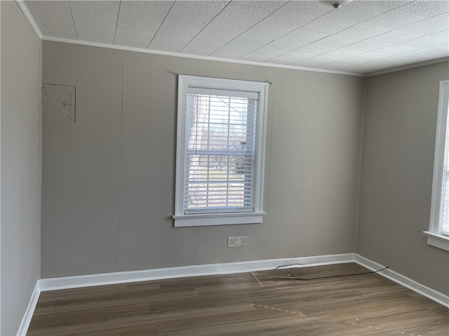 unfurnished room with ornamental molding, baseboards, and wood finished floors