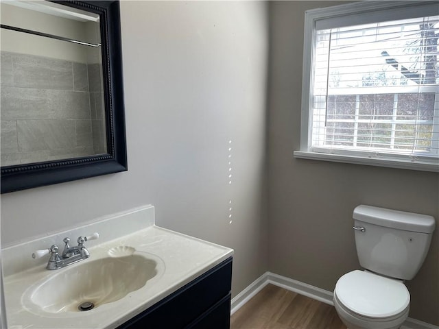 bathroom with plenty of natural light, vanity, toilet, and wood finished floors