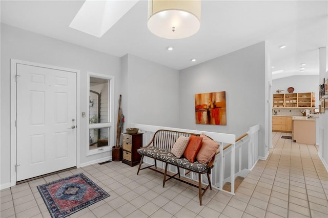 foyer featuring light tile patterned floors, vaulted ceiling with skylight, and recessed lighting