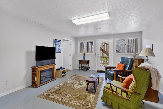 living area with a glass covered fireplace and baseboards