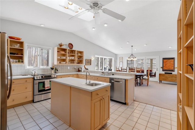 kitchen featuring open shelves, stainless steel appliances, a sink, and light countertops