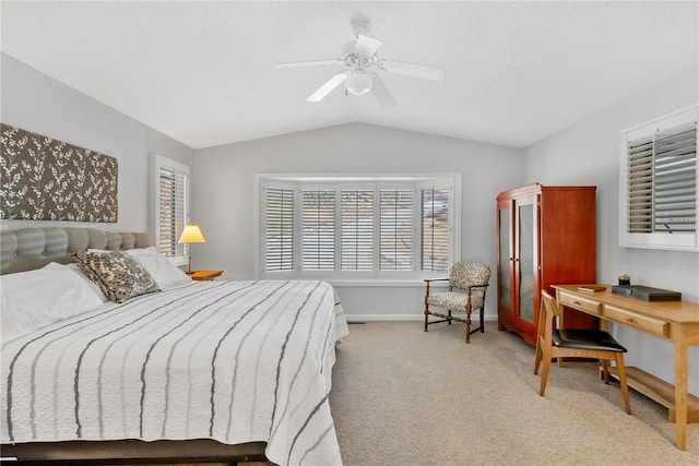 bedroom with a ceiling fan, light colored carpet, vaulted ceiling, and baseboards