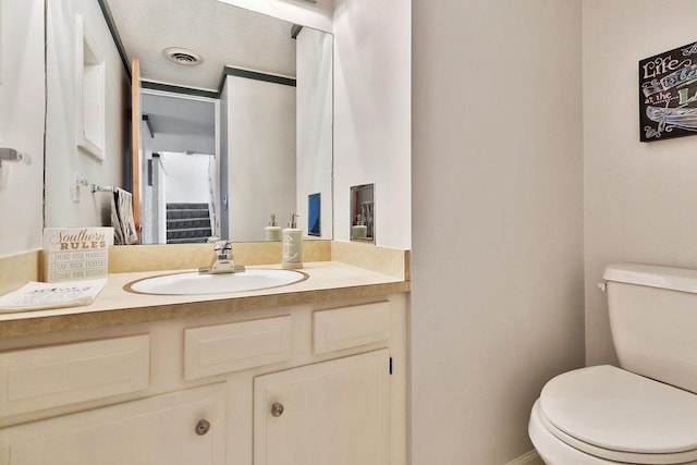 bathroom featuring visible vents, vanity, and toilet