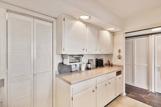 kitchen with recessed lighting, light countertops, and white cabinetry