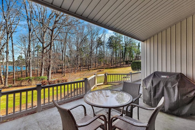 wooden deck with outdoor dining area, grilling area, and a lawn