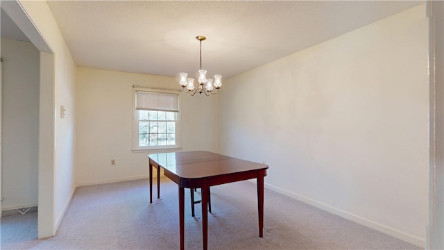 dining area with a chandelier, light carpet, and baseboards