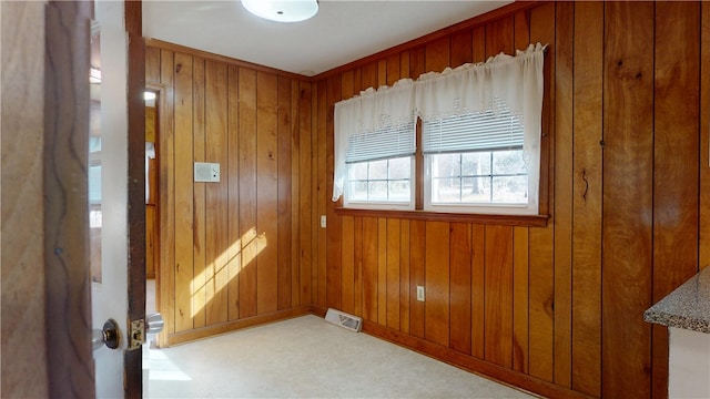 spare room featuring visible vents and wood walls