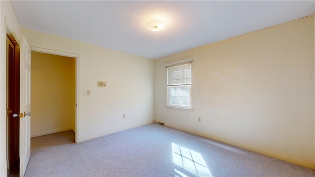 unfurnished room with baseboards, visible vents, and carpet flooring