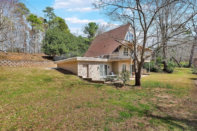 back of house featuring a lawn, a deck, and a patio